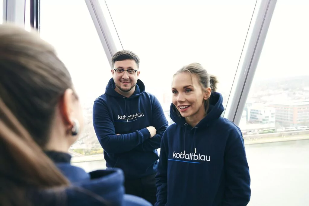 Mitarbeiter*innen im kobaltblau Hoodie
